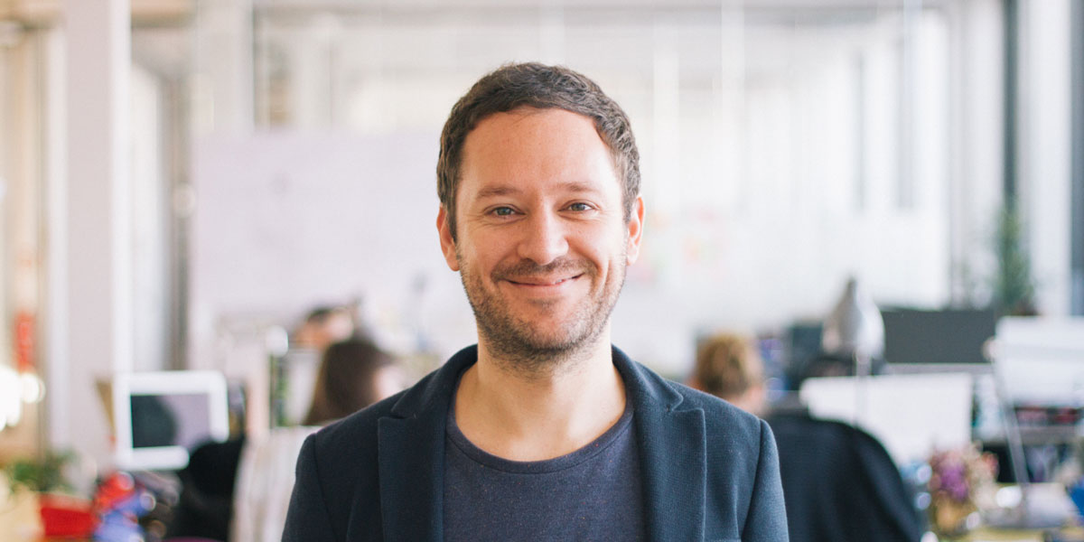 Why take UX Fundamentals UX designer standing in an office and smiling at the camera
